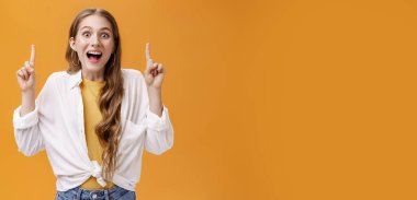 İyi tarafından bak. Karizmatik, mutlu, coşkulu, beyaz bluzlu, çekici bir kadın. Çenesi açık, neşeli bir gülümseme. Yükselmiş işaret parmaklarıyla işaret ediyor..