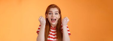 Yakın plan heyecanlı kızıl saçlı şanslı kız birincilik ödülünü kazanıyor, geniş çapta gülümsüyor mükemmel sonuç alıyor, yumruk pompası zaferi, şaşkın bakış kamerası, zafer jesti, bağırma sevinci.