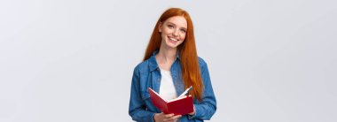 Karizmatik yetenekli, kızıl saçlı, ders çalışan, öğretmenden sonra not alan, günlüğüne yazan, beyaz arka planda neşeli duran karalamalar çizen kız öğrenci..