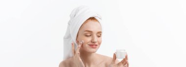 güzel model beyaz yüzünde kozmetik krem tedavisi uygulayarak