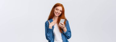 Oh çok tatlı. Dokunulmuş ve memnun edilmiş kızıl saçlı kız arkadaş aşk emojisi, hoş bir mesaj, mesajlaşma, sohbet, akıllı telefon, dokunmatik göğüs ve gülümseyen cep telefonu görüntüsü alıyor..