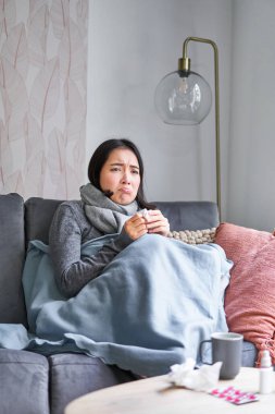 Koreli kadın kendini kötü hissediyor, hapşırıyor, öksürüyor, üşütüyor, ateşi ve ateşi olan evde kalıyor, ilaç alıyor..