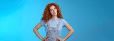 Neşeli, motive olmuş, çekici kızıl saçlı, kıvırcık saçlı, kızıl saçlı, el ele tutuşmuş, kendine güvenen, kendine güvenen, kendinden emin gülümseyen, ilham veren kız..