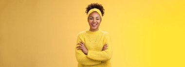 Ciddi, güçlü, güzel görünüşlü, gülümseyen, Afro-Amerikan kadın feminist blogcu el ele tutuşan, kendinden emin, sırıtan, çalışma sürecini zevkle izleyen, sarı arka planda duran biri..