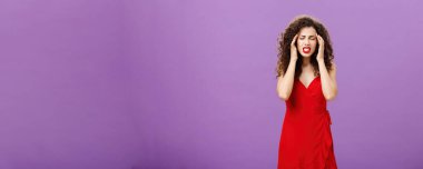 Odaklanmaya çalışan ve düşünceleri bir araya getiren bir kadın şakakların üzerinde parmaklarını tutarak baskı hisseden bir kadın. Ve dişlerini sıkarak gözlerini kapatıyor. Mor arka planda şiddetli migren ve baş ağrısı ile ayakta duruyor.