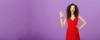 Ben seni korurum. Hoş görünümlü, zarif, kıvırcık saçlı, kırmızı elbiseli, el ele tutuşmuş, onaylanmış ve gülümseyen güzel Avrupalı bir kadın.