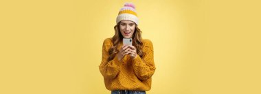 İnanılmaz çekici, şık bir kadın, akıllı telefondan harika bir terfi online alışverişe hazır heyecanlı bir şekilde gülümseyen, sarı arka plan pozu veren, heyecanlı bir cep telefonu görüntüsü. Teknoloji konsepti