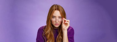 Yaşam tarzı. Sorgulanmış ve kararsız kızıl saçlı sevimli bayan dedektif. Alnının altından şüpheli görünüyor. Gözlüklerini çıkarıyor ve mor üzerine şüpheli ve belirsiz kameralara bakıyor.