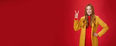 Mutlu, neşeli, kızıl saçlı, sarı ceketli, belinde çilleri olan, kendine güvenen, barış sembolü, keyifli, dövülen hava koşulları olan bir kadının portresi. Anlaşıldı.