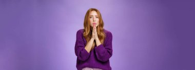 Kederli ve üzgün kızıl saçlı kadın, sıcak kazaklı, yakarış içinde el ele tutuşan, dua eden, kaşlarını çatan, merhamet dileyen yardım dileyen, ya da rahatsız edici bir ifadeyle affedilmeyi bekleyen..