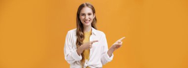 Yaşam tarzı. Dost canlısı, hoş ve şık, genç bir bayanın tişörtünün üzerinde, solu gösteren dalgalı sarı saçlı ve portakala karşı mutlu poz veren belden yukarı pozu.