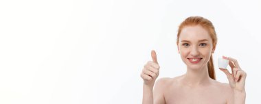 Yüzüne krem sürerken gülümseyen güzel bir kadının portresi. Fotokopi alanı ile izole edilmiş.