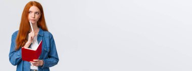 Ciddi ve kararlı patronluk taslayan, elinde kalem tutan, düşünceli, sırıtan ve şöyle düşünen kızıl saçlı kız: 