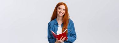 Belden yukarı, sevimli kızıl saçlı genç kız favori üniversite dersinde not alıyor, elinde kalem ve kırmızı defter, gülümseyen kaygısız kamera, bir şeyler yazıyor, yapılacaklar listesi yapıyor..