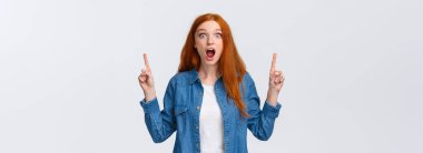 Şaşırmış, büyülenmiş, kızıl saçlı, soluk soluğa, nefes nefese, hayret verici bakışlı, güzel ve inanılmayacak bir şey gören, parmaklarını havaya kaldıran beyaz bir kadın..