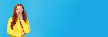 Vay canına. Şaşırmış kız sırrını öğrendi ya da gerçeği öğrenince şoka girdi. Şaşırmış kızıl saçlı kadın kameraya bakıyor, nutku tutulmuş, nefes nefese kalmış kapak ağzı açık, şaşkın, mavi arka plan.
