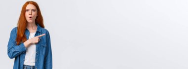 Bu da ne? Hoşnutsuz, gergin ve sinirli kızıl saçlı, patronluk taslayan, doğru açıklamayı bekleyen, kafası karışmış, üzgün, ayakta duran, beyaz arka planda rahatsız olan,.