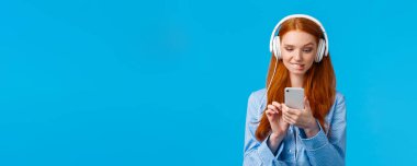 Belden yukarı portre, kararsız, gece elbisesi giymiş, seçici, sevimli, kızıl saçlı, dudak ısıran, akıllı telefon ekranıyla baştan çıkarıcı görünen, riskli mesajlar gönderen, müzik kulaklıkları dinleyen....