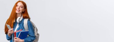 Neşeli, arkadaş canlısı ve karizmatik kızıl saçlı kadın neşe içinde gülüyor, arkadaşlarına mesaj atıyor, akıllı telefonlarla sohbet ediyor, üniversite hayatının tadını çıkarıyor, sırt çantası ve not defterleriyle kampüse gidiyor..