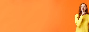 Jestler, kış tatilleri ve insanlar konsepti. Şehvetli ve cilveli tatlı kızıl saçlı kadın, kız sürpriz hazırlayıp sırrını sakla, işaret parmağınla dudağına bas, gülümse ve sus, sus..