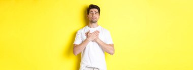 Romantik ve nostaljik bir adam, kalbi tutan, gözlerini kapatan ve sarı arka planda duran bir şeyi hatırlayan..