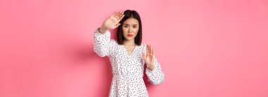 Ürkek ve korkmuş Asyalı kadın kendini savunuyor. Korumak için kollarını kaldırıyor. Kurban saldırıya uğruyor..