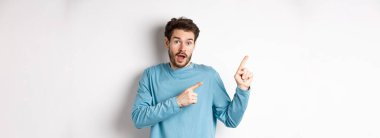 Harika bir tanıtım teklifi sunan, sol üst köşedeki logoyu işaret eden, heyecanlı görünen, ürün öneren, beyaz arka plan.