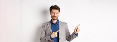 Kötü bir fikir. Memnun olmayan şüpheci takım elbiseli adam sırıtıyor ve kaşlarını çatıyor. Üzücü haberleri işaret ediyor. Kameraya tereddütlü bakıyor..