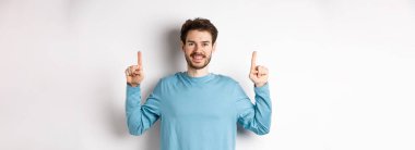 Fotokopi alanında reklam yapan, parmaklarını kaldırıp gülümseyen sakallı genç bir adamın resmi..