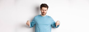 Şüpheci çocuk, beyaz arka planda duran, kötü tanıtım teklifine bakan, ve hayal kırıklığına uğramış,.