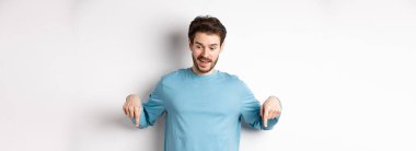 Yakışıklı beyaz adam, etkilenmiş ve mutlu yüzüyle, gülümsüyor ve 