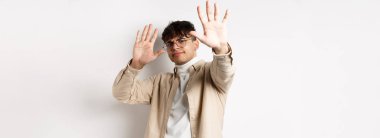 İsteksiz ve rahatsız bir adamın, teklifi engellemek için ellerini kaldırması, reddetmesi ve durmasını istemesi, hayır demesi, bir şeyi reddetmesi, beyaz arka planda durması..