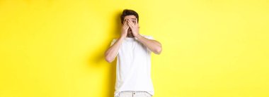 Utangaç adam gözlerini kapadı ama parmaklarının arasından sarı arka planda duran garip bir şeye baktı..