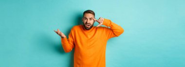 Kafasını işaret eden kızgın adam, sen deli misin? Açık mavi arka planda dikilen birini azarlıyor musun? Boşluğu kopyala