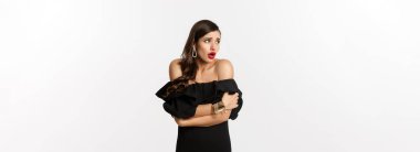 Korkmuş ve şok olmuş cazibeli bir kadın görüntüsü etrafa bakıyor, kendini rahatlatıyor, beyaz arka plana karşı alarma geçiyor..