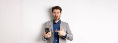 Heyecanlı takım elbiseli adam dedi ki vay canına, akıllı telefondan bir şey buldum, cep telefonundan etkilenmiş, beyaz arka plan.