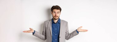 - Bilmiyorum. Kafası karışmış işadamı ellerini yana açmış ve cahil görünüyor, yardımcı olamıyor, hiçbir fikrim yok, takım elbise içinde beyaz arka planda duruyor..