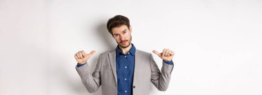 Kendine güvenen, profesyonel görünümlü, kendini gösteren, kendi reklamını yapan, beyaz arka planda duran kendine güvenen bir adam..