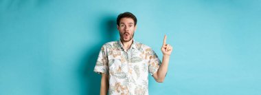 Havai tişörtlü beyaz turist şaşırdı, parmağını kaldırdı ve 