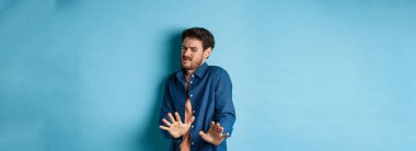 Bir adamın görüntüsü tiksindirici ve iğrenç bir şeye bakar, korkunç bir şeyden uzaklaşır ve mavi arka planda durarak onu engeller. Boşluğu kopyala