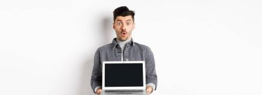 Heyecanlı adam boş dizüstü bilgisayar ekranını tanıttı. 