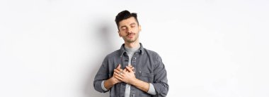 Nostaljik bir adam kalbe sarılır, beyaz arka planda duran hassas anıları hatırlar..