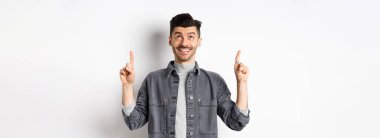 Bıyıklı neşeli beyaz adam yukarı bakıyor, gülümsüyor, hayal kuruyor, havalı bir terfi anlaşması yapıyor, beyaz arka planda duruyor..