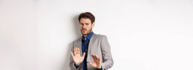 Uzak dur benden. İsteksiz işadamı endişeli bir yüz ifadesiyle geri adım atar, kötü bir teklifi engellemek için ellerini kaldırır, iğrenç bir şeyi reddeder, tiksinti duymaktan kaçınır, beyaz bir altyapısı vardır..