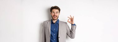 Heyecanlı sakallı iş adamı hayran hayran hayran hayran hayran hayran hayran hayran bakıyor ve evet diyor, onaylıyor ve iyi bir ürün gibi beyaz arka planda duruyor..