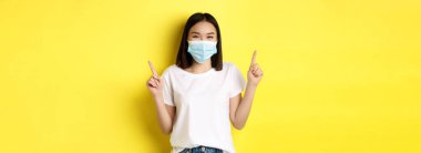 Covid-19, salgın hastalık ve sosyalleşme konsepti. Beyaz tişörtlü ve Coronavirüs 'ten gelen tıbbi maskeli genç Asyalı kadın..