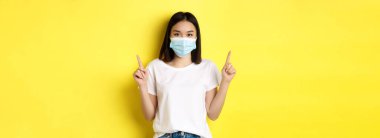 Covid-19, salgın hastalık ve sosyalleşme konsepti. Beyaz tişörtlü ve Coronavirüs 'ten gelen tıbbi maskeli genç Asyalı kadın..