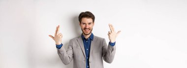 Heyecanlı ve başarılı bir iş adamı beyaz arka planda duran mutlu, motive olmuş ve pozitif hissediyor..