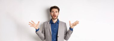 Ceketli şok olmuş sakallı adam ellerini yana yatırdı, nefes nefese kaldı ve endişeli görünüyordu, pembe arka plan giysisine karşı duruyordu..