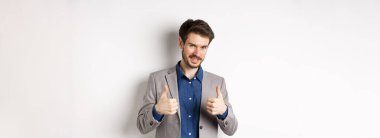 - Çok iyi. Gülümseyen yakışıklı yönetici onaylanmış, gururlu ve memnun görünüyor, evet diyor, iyi iş çıkarıyor, beyaz arka planda duruyor..